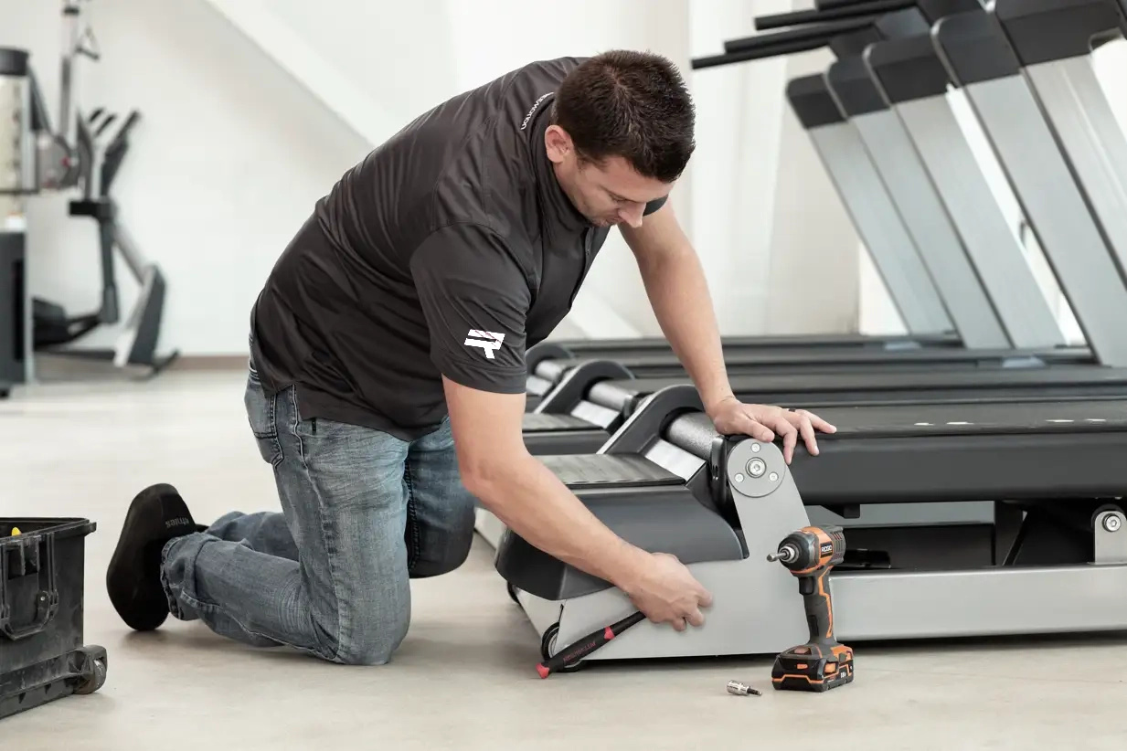 Técnico certificado dando mantenimiento preventivo a una caminadora Freemotion
